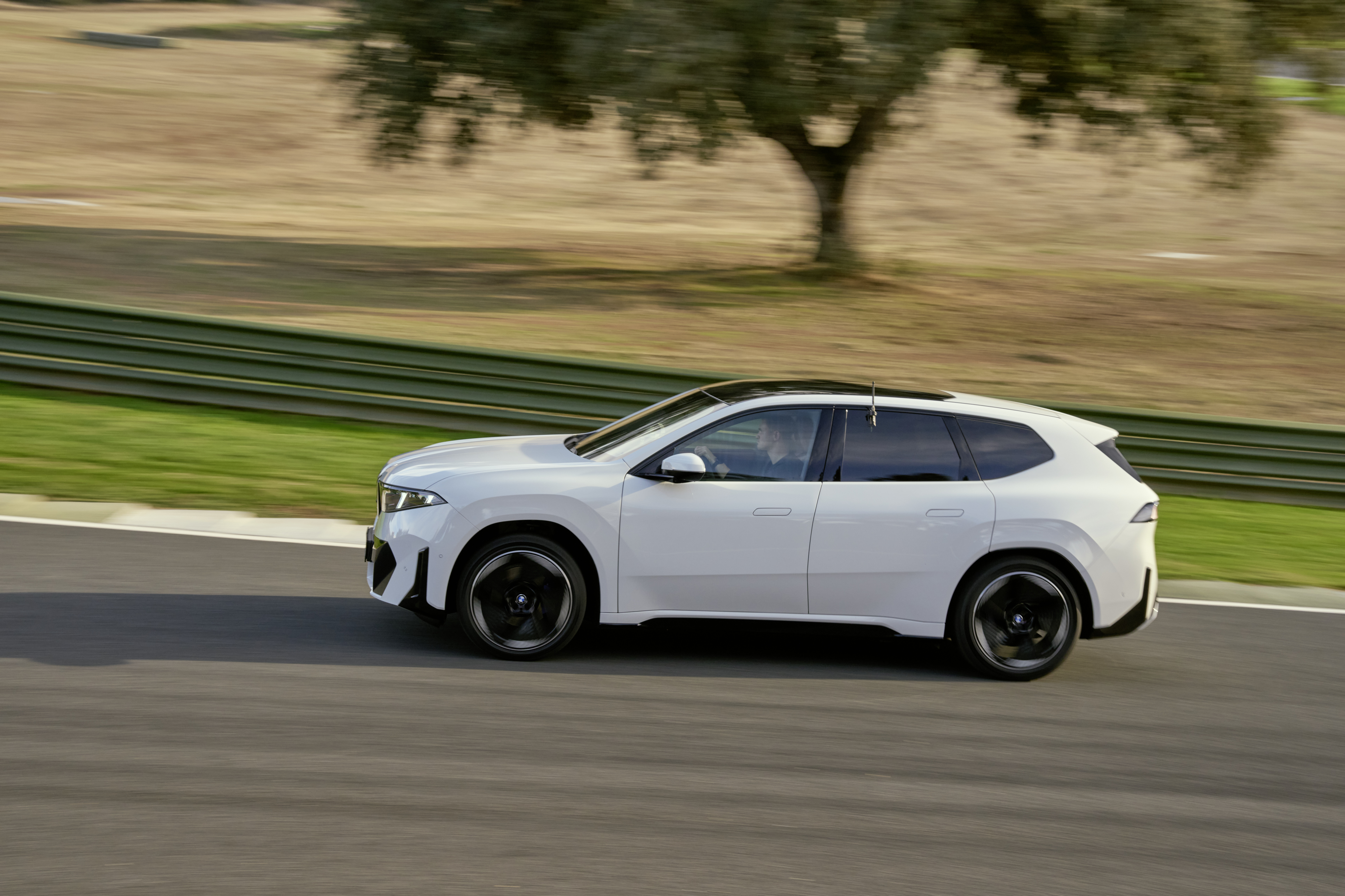 BMW iX3 Alpine White BMW iX3 Alpine White в движении, боковой ракурс