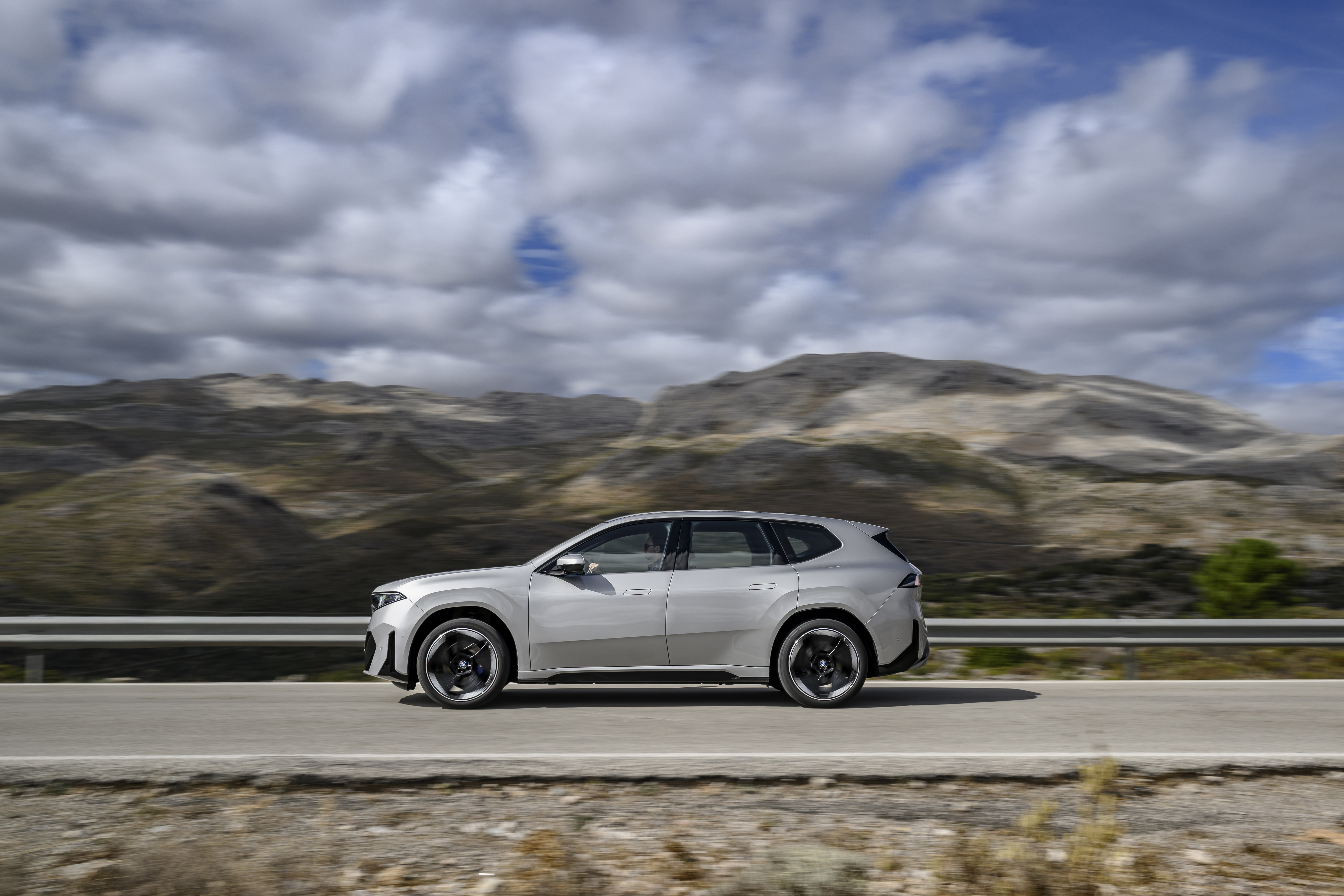 BMW iX3 Space Silver BMW iX3 Space Silver в профиль на дороге